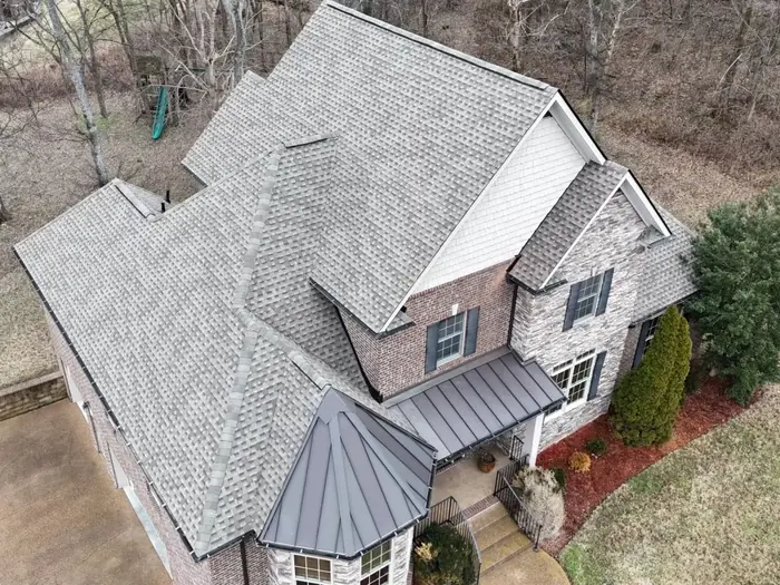 Brick home with a light weathered-wood shingle roof replacement