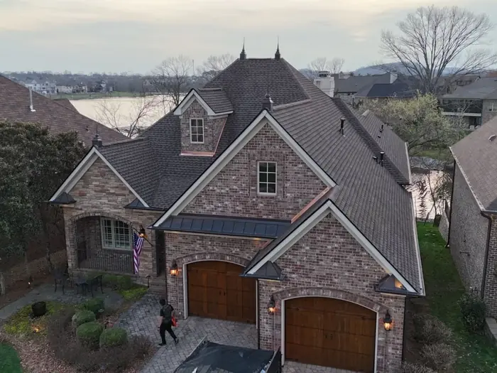 Stone and brick home with a new roof and cedar garage doors in Williamson County