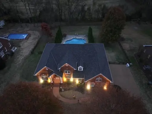 Twilight drone photo of a completed roof replacement on a lakeside home