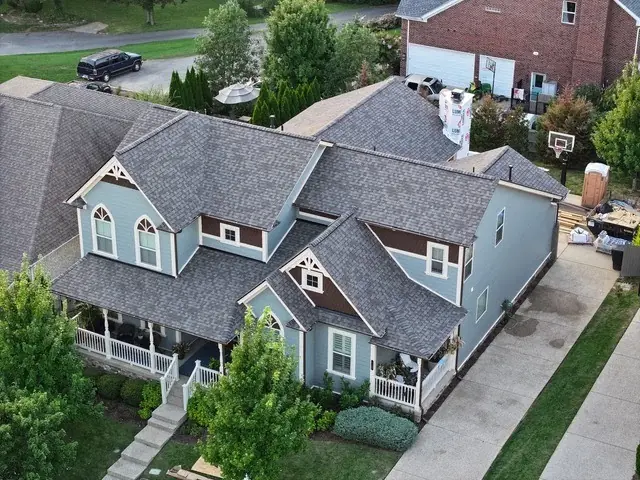 Light blue coastal-style home with a new shingle roof and dormers