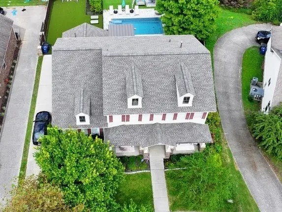 Aerial of a home with a new roof, pool and detached garage