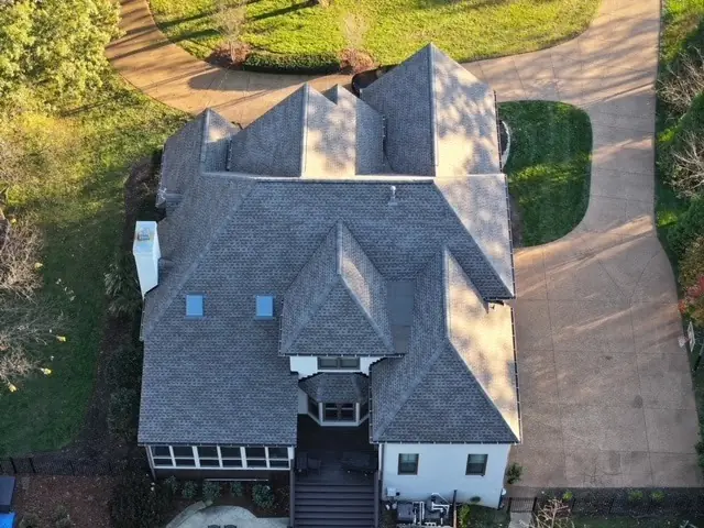 Two-story home with sunroom and a completed shingle roof replacement