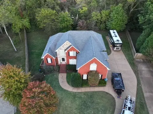 Red brick home with a new roof and detached RV garage