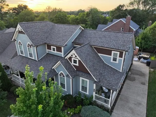 Sunset drone view of a blue craftsman home with a new architectural shingle roof in Middle Tennessee