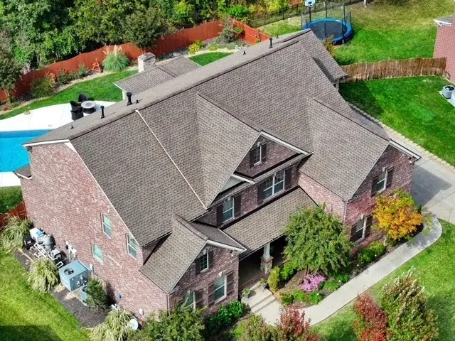 Aerial view of a brick home with a new roof, pool and screened porch