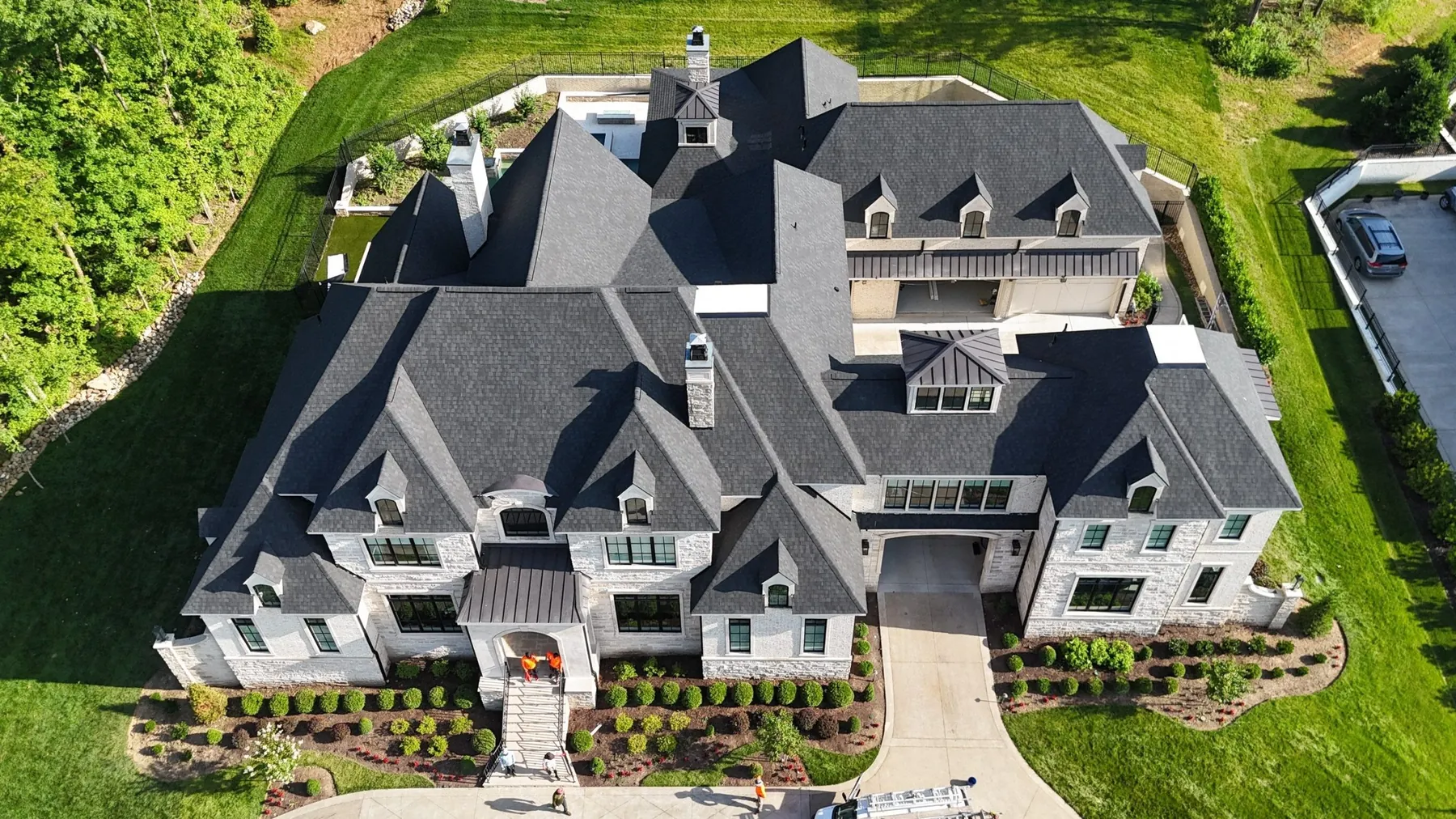 Aerial view of a stone estate with a new CertainTeed Charcoal Black architectural shingle roof, installed by Three Stone in Middle Tennessee