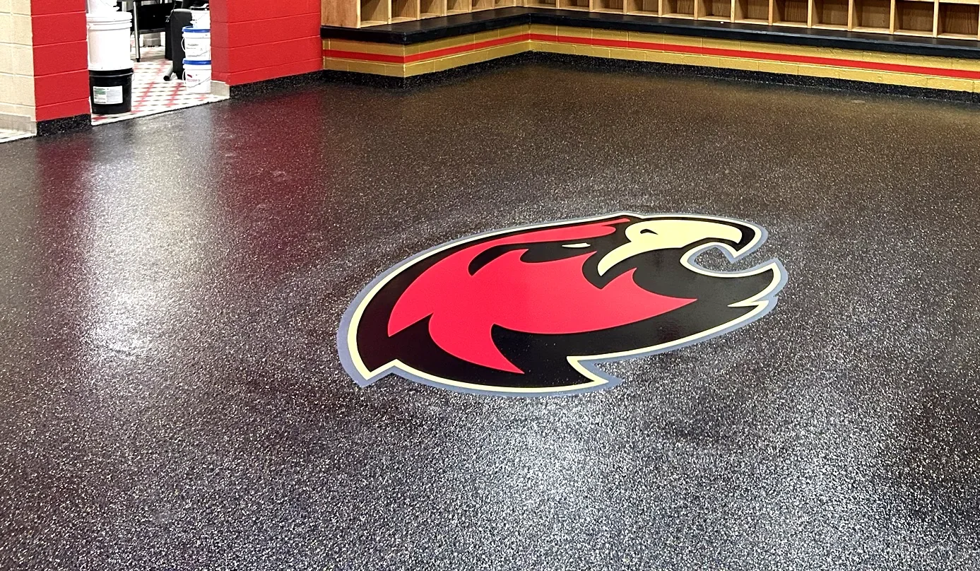 The Raptors logo inlaid in the Penntek flake floor of the Ravenwood High School locker room, installed by Three Stone