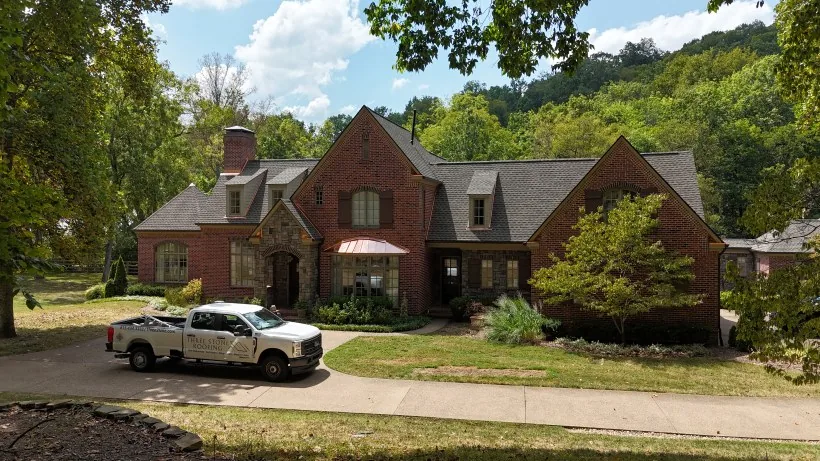 Three Stone truck parked outside a brick home during a roof replacement in Middle Tennessee